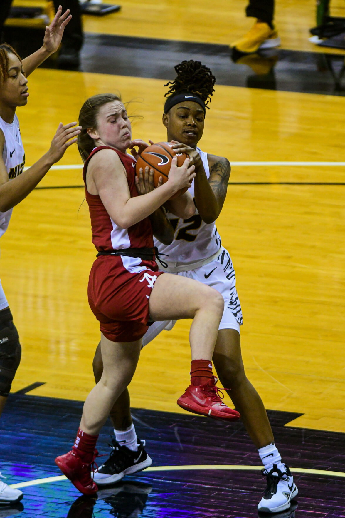 Alabama guard Hannah Barber and University of Missouri guard Shug Dickson wrestle for the ball